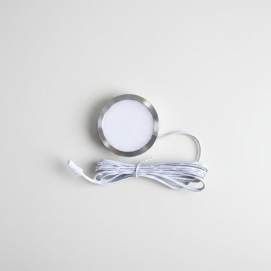 A round recessed LED light fixture with a brushed silver metal rim and a white diffuser, shown with its coiled white power cable on a plain white background.