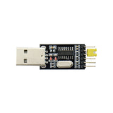 A USB to TTL converter module, with a visible USB connector on one end and a row of pins on the other, against a white background.
