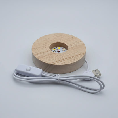 A round wooden USB LED light with a visible wood grain finish, featuring a built-in white circuit board with yellow LED chips. It is shown with its white power cable and inline switch on a plain white background.
