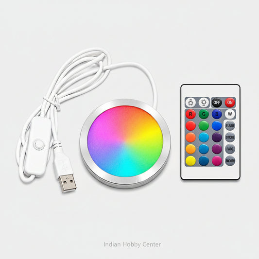 A round RGB LED light strip controller with a white USB cable and a white remote control, displayed on a clean white background.